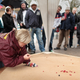 Former American National Marbles Champion Debra Stanley-Lapic plays a shot at the British and World Marbles Championship on April 2, 2010 in Tinsley Green, England. She is on her hands and needs, with one hand in a glove, holding a marble and looking very serious. People are standing around watching.
